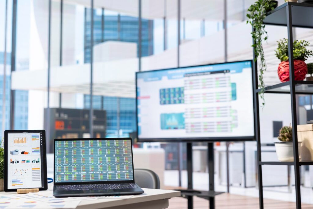 Interfaz digital de un CMMS en pantalla y laptop, mostrando gestión de datos y programación de mantenimiento hospitalario.